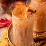 An apple cider drink on a gold tin platter.