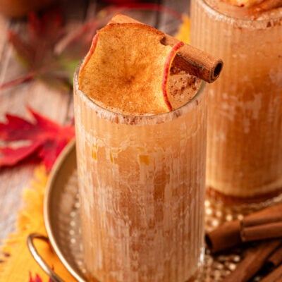 An apple cider drink on a gold tin platter.