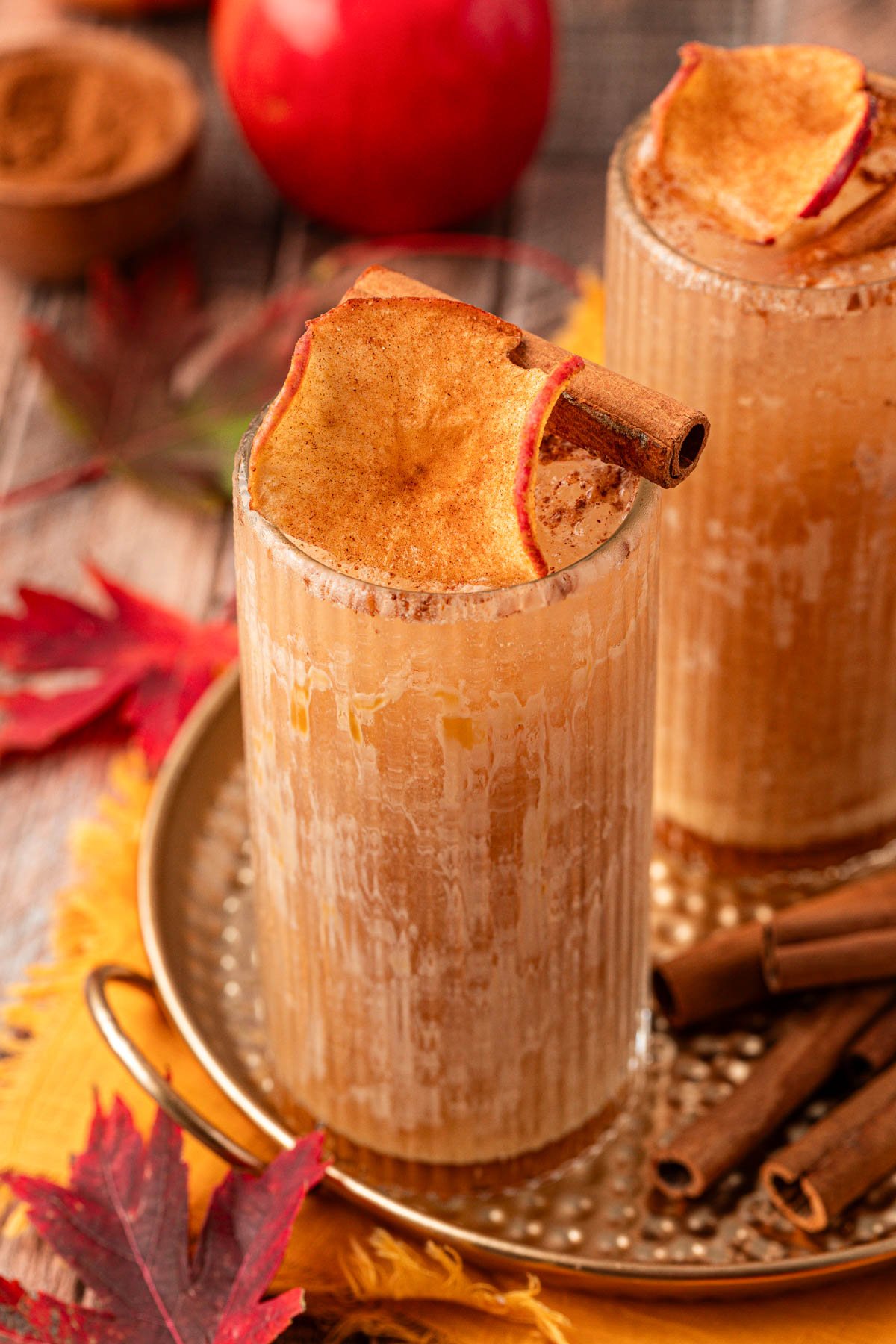 An apple cider drink on a gold tin platter. 
