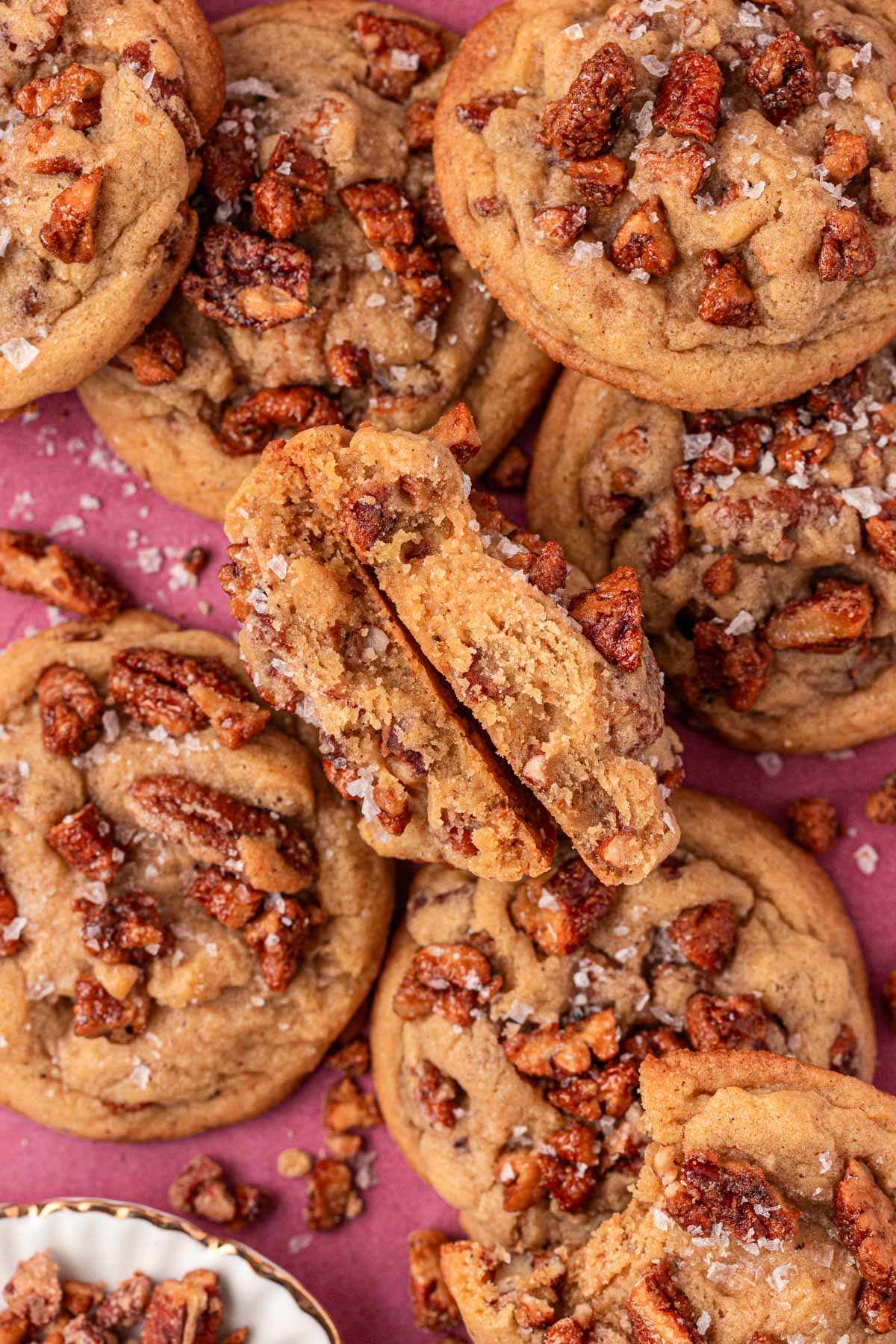 Overhead photo of maple pecan cookies on a maroon table.