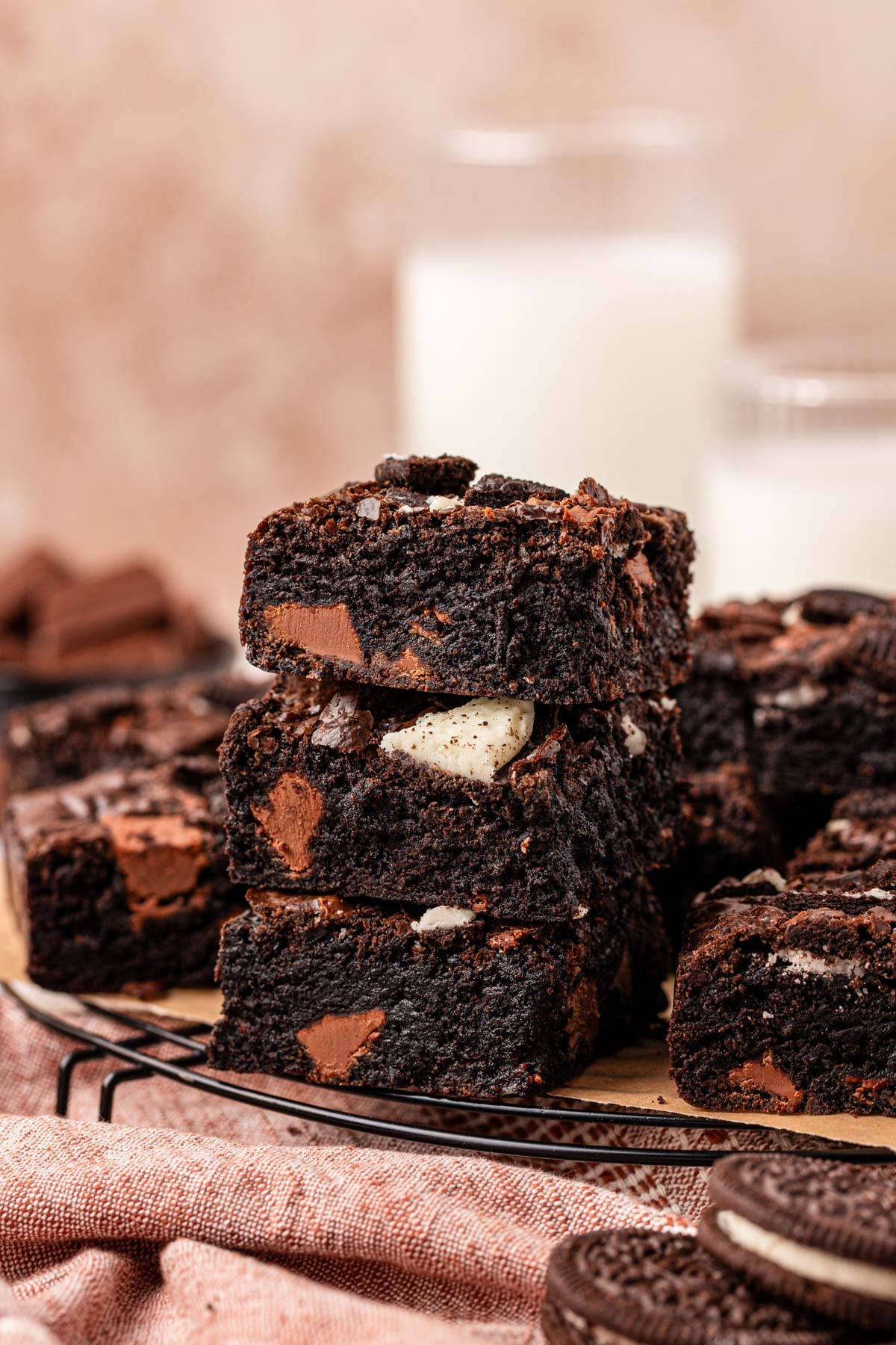 Close up of a stack of three brownies on a wire rack with more behind them.
