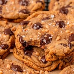 Close up photo of a stack of three toffee chocolate chip cookies, the top one is missing a bite.