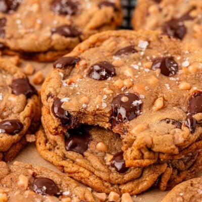 Close up photo of a stack of three toffee chocolate chip cookies, the top one is missing a bite.