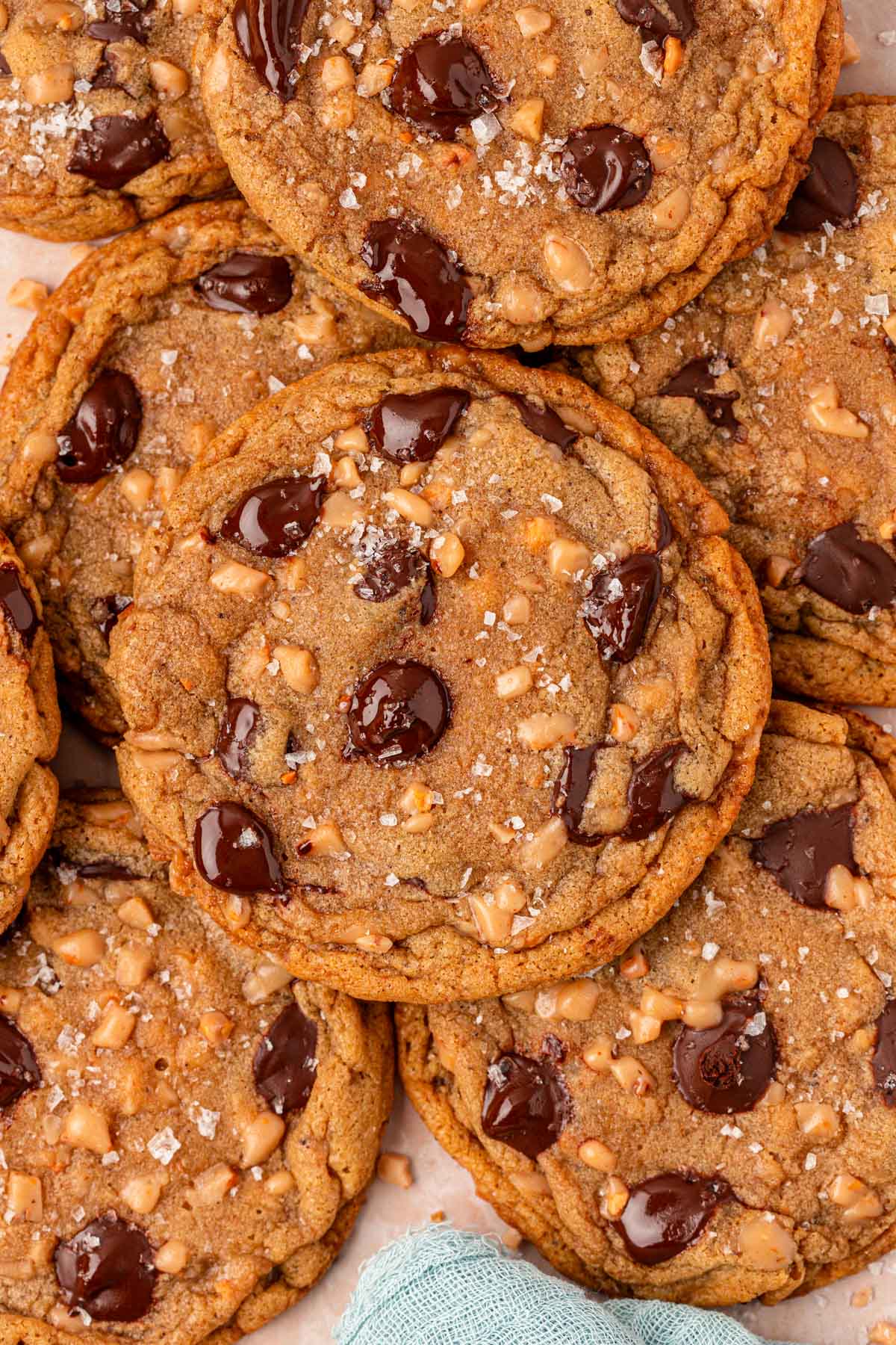 Close up of toffee chocolate chip cookies layered on a plate.