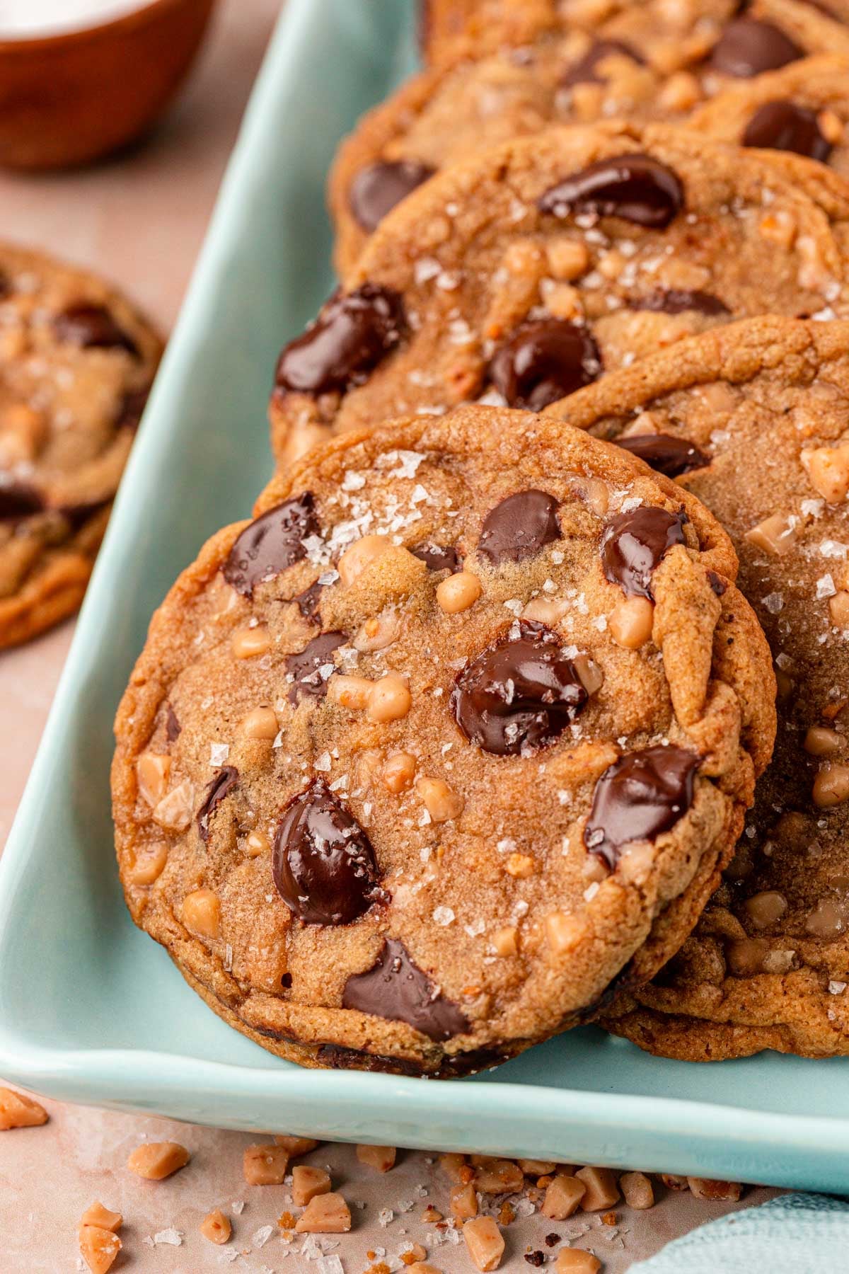 Close up of brown butter chocolate chip cookies with toffee on a blue pan.