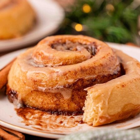 Eggnog cinnamon rolls on a white plate.