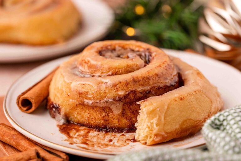 Eggnog cinnamon rolls on a white plate.