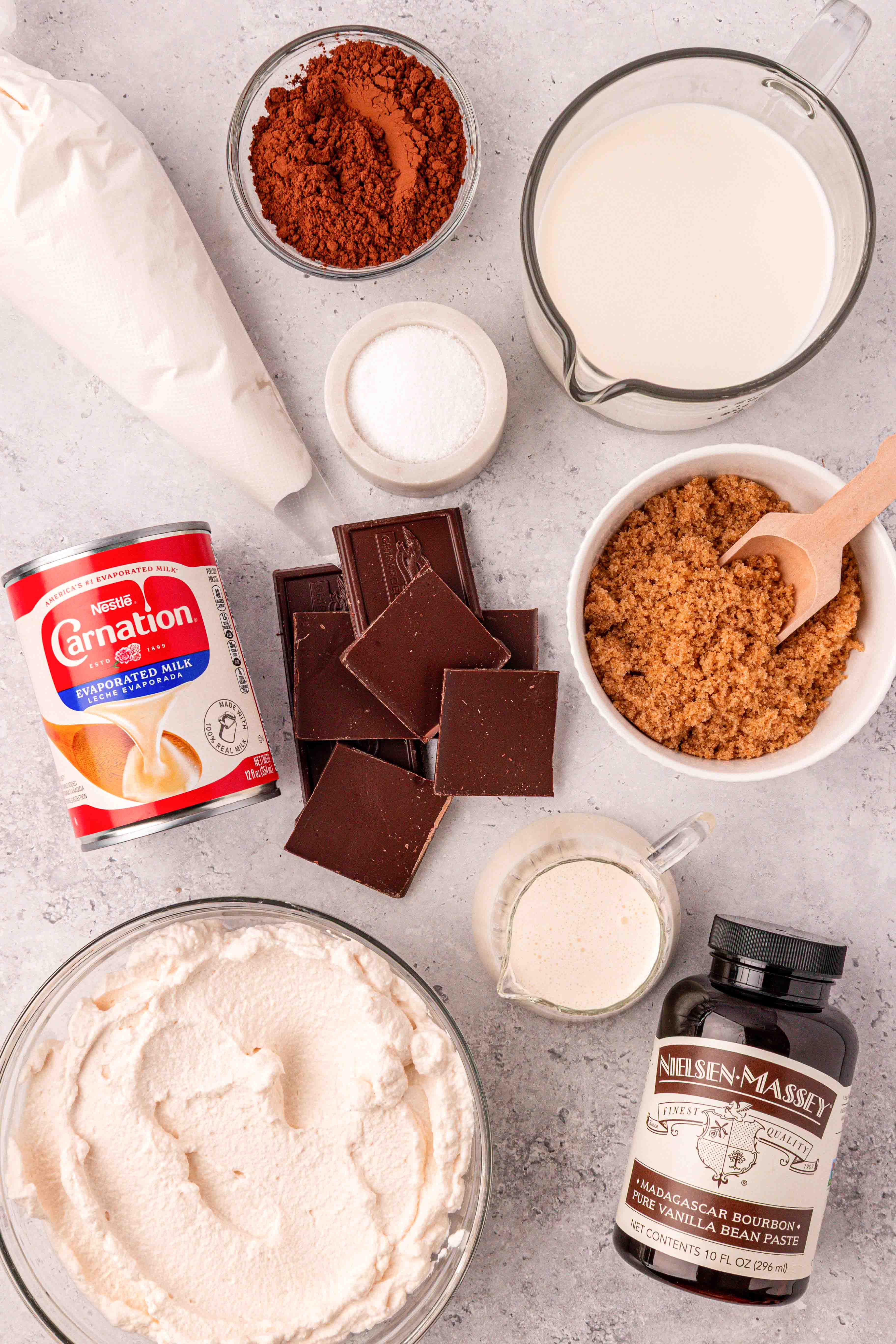 Ingredients to make hot chocolate with whipped cream on a table.