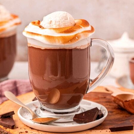 Close up of two mugs on NYC style hot chocolate on a wooden serving board.