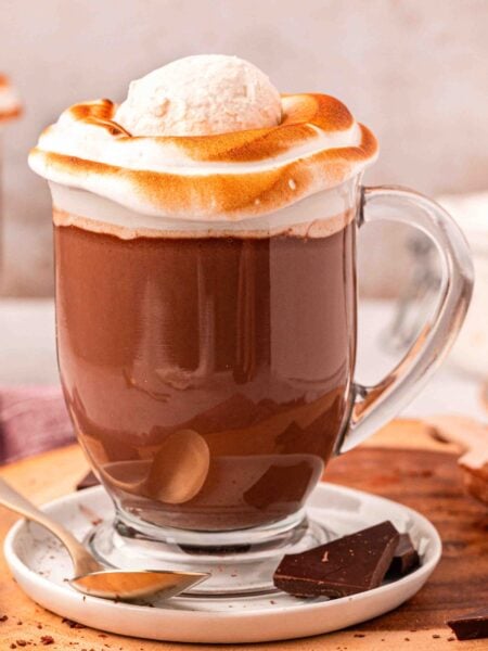 Close up of two mugs on NYC style hot chocolate on a wooden serving board.
