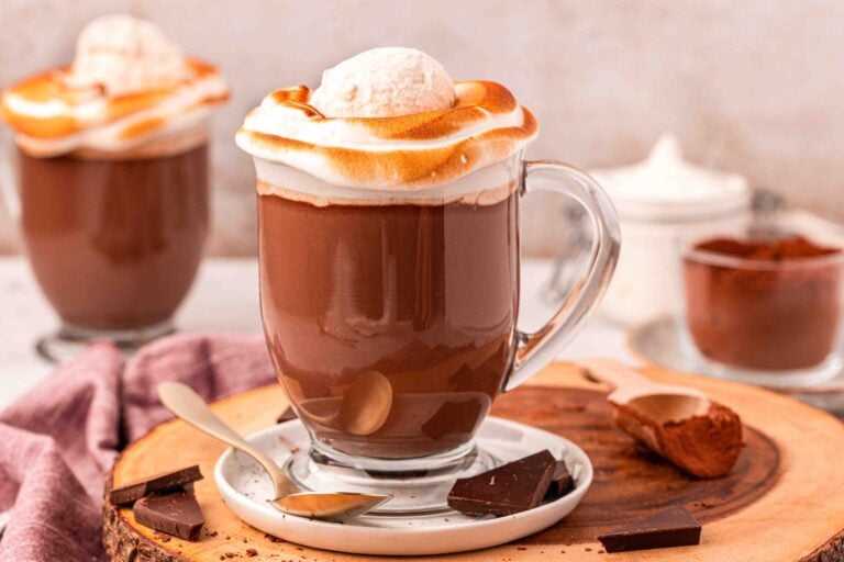 Close up of two mugs on NYC style hot chocolate on a wooden serving board.