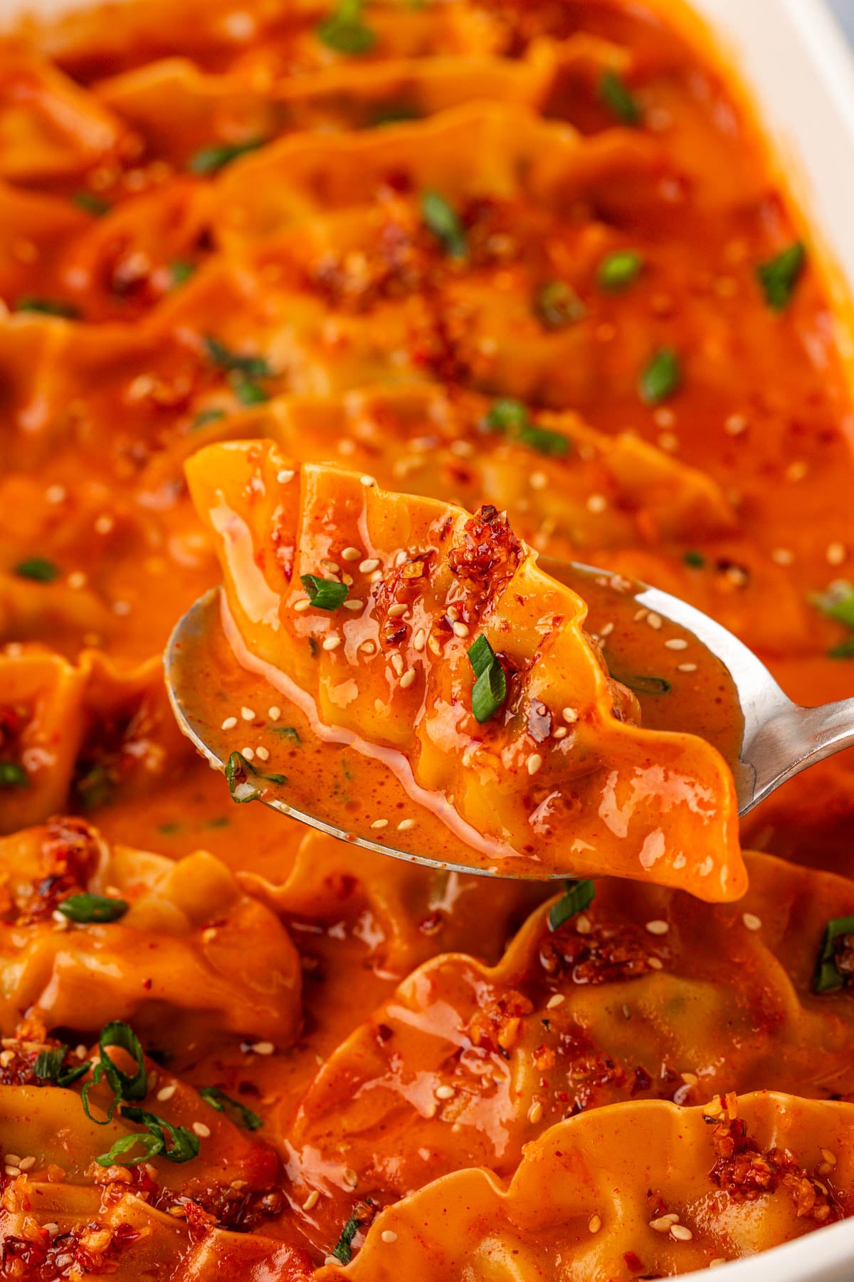 Viral baked dumpling in a pan with a serving spoon scooping one out.