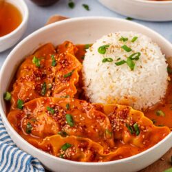 A white bowl with white rice and viral baked dumplings in it.