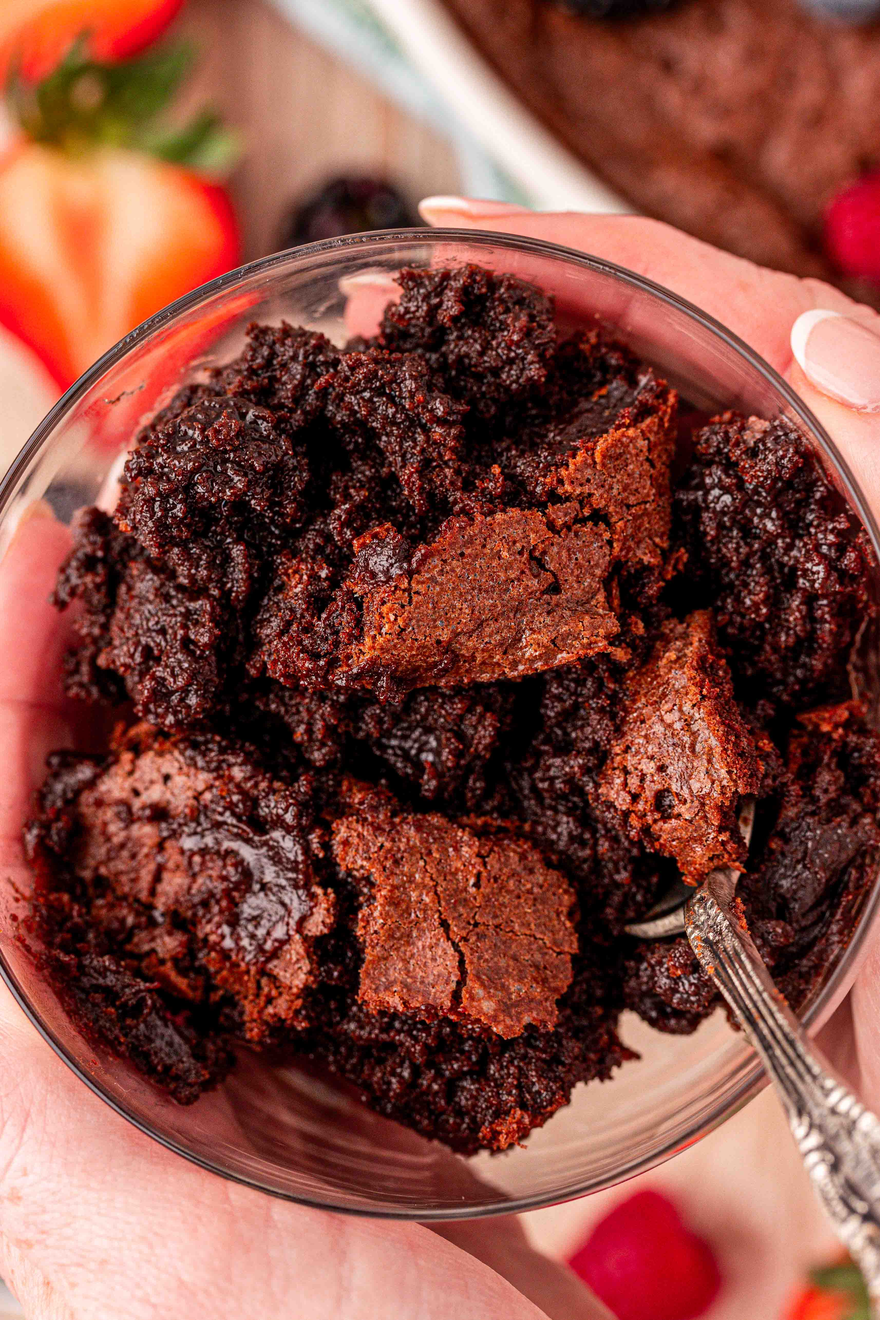 A bowl of brownie pudding in a woman's hands.