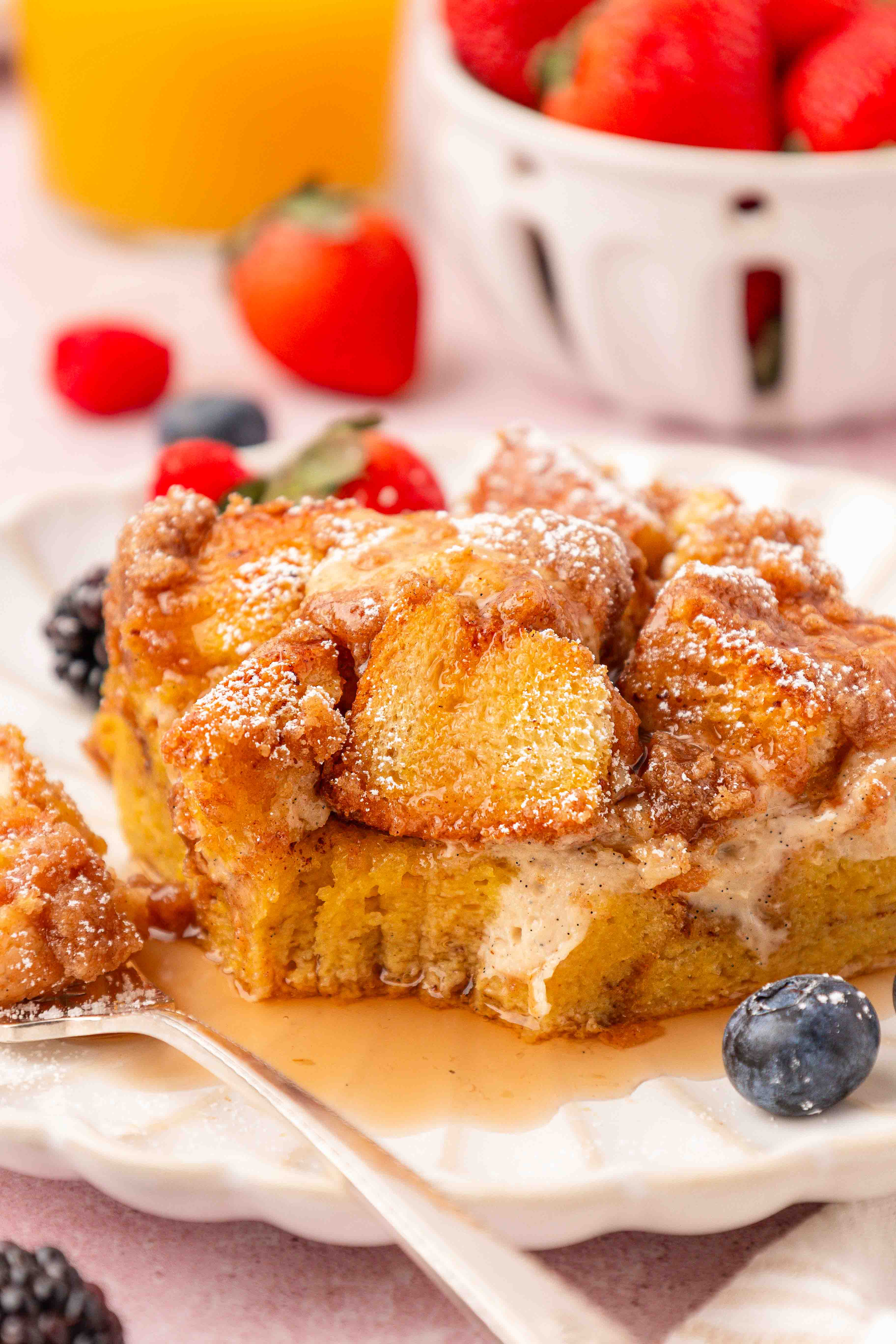 A slice of french toast casserole on a white plate with a fork.
