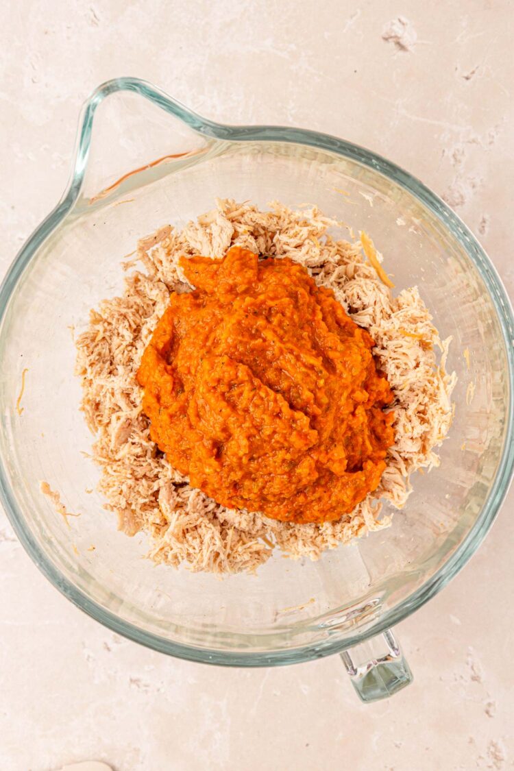Pureed veggies with shredded chicken in a bowl.