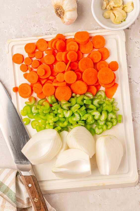 Onion, celery, and carrots being chopped.