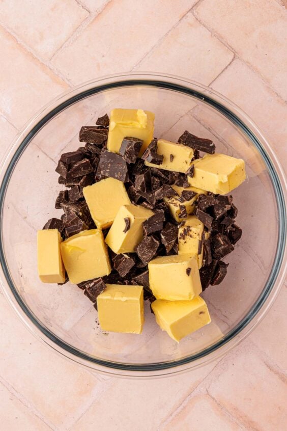 Butter cubes and chocolate chunks in a glass bowl.