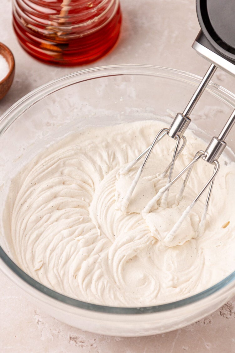 Honey whipped cream being made in a bowl.