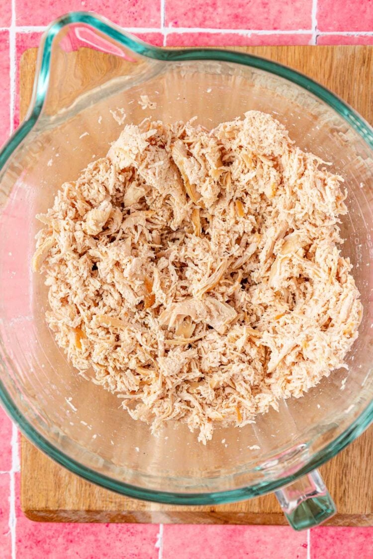 Chicken shredded in a stand mixer bowl.