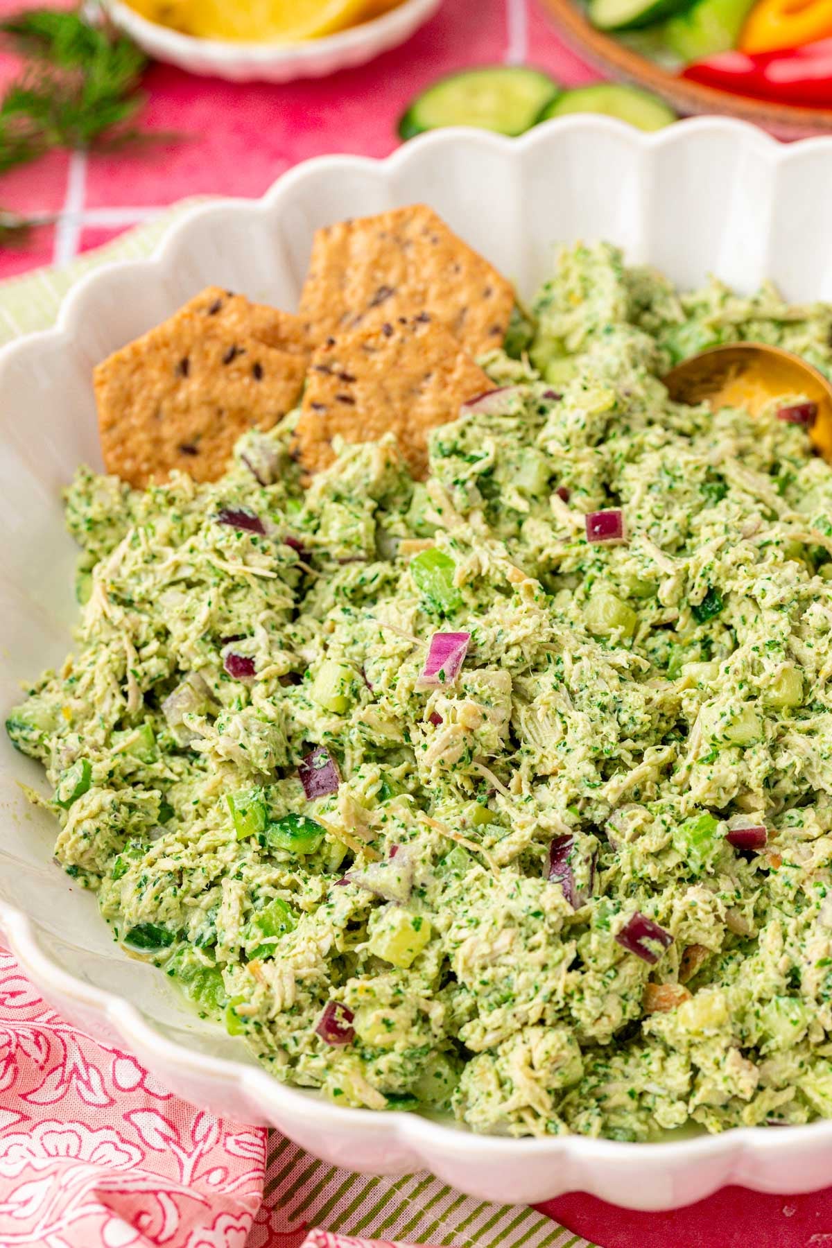 Close up of a white bowl filled with green goddess chicken salad.