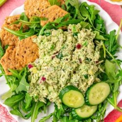 Overhead photo of a plate of green goddess chicken salad with crackers and arugula.