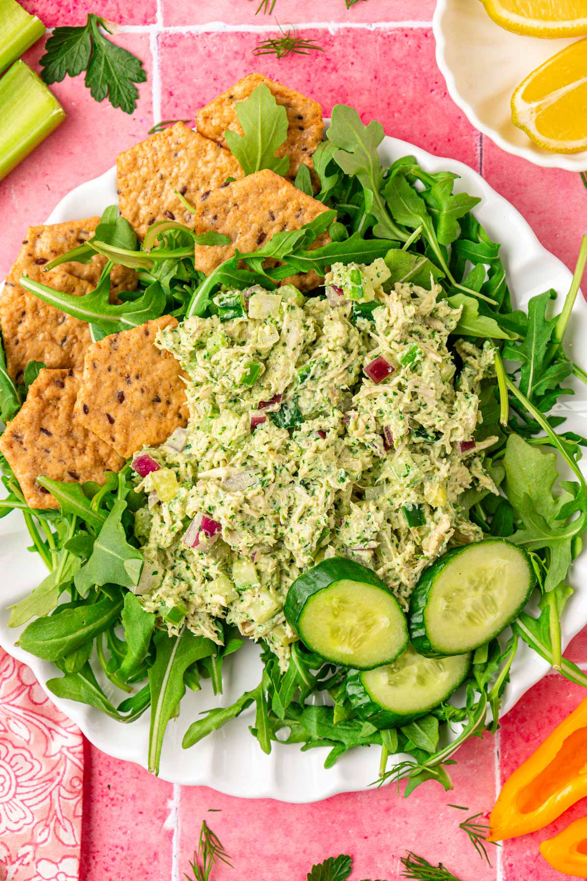Overhead photo of a plate of green goddess chicken salad with crackers and arugula.