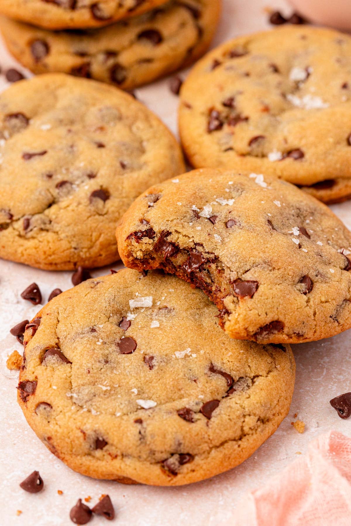 Close up of cookies on a counter layered on top of each other. One is missing a bite.