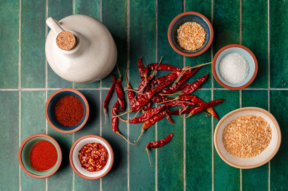 Ingredients to make chili onion crunch on a green tile.