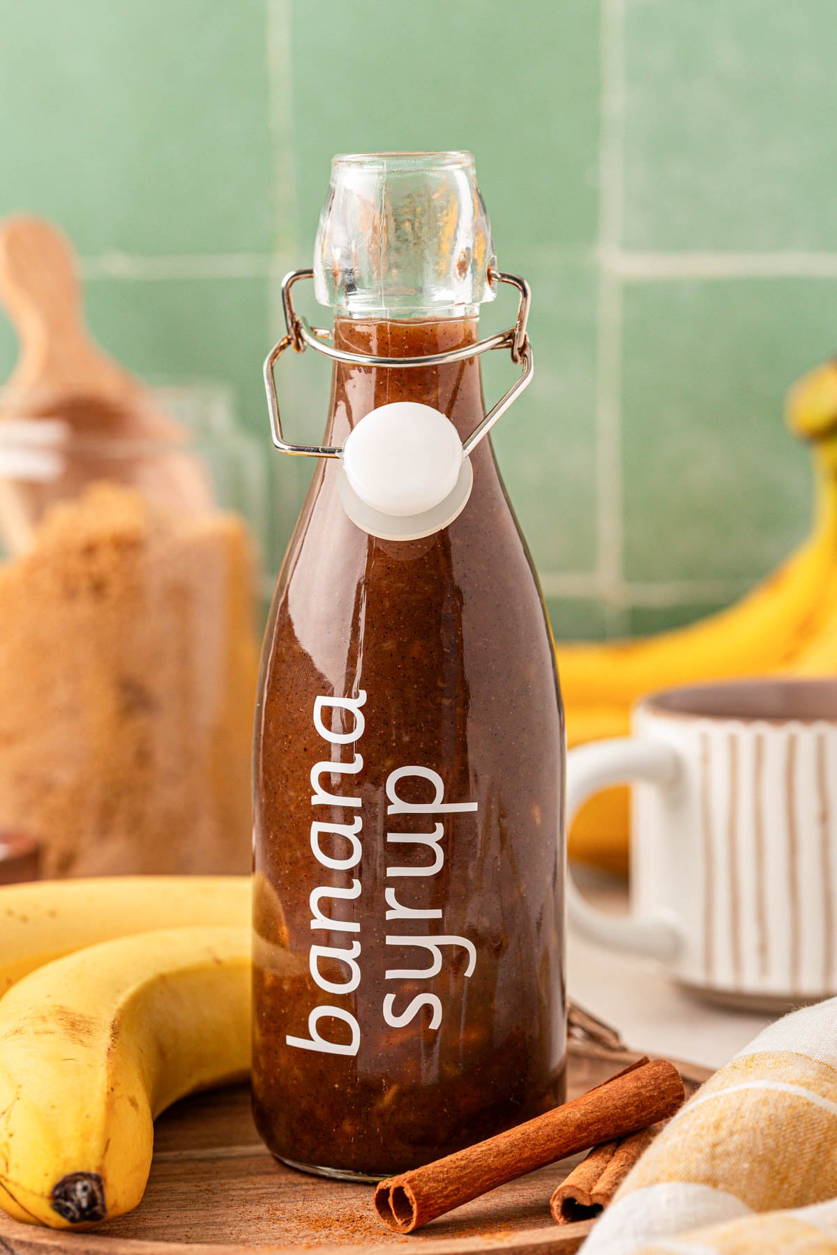 Close up of a glass bottle filled with homemade banana syrup for coffee and desserts.