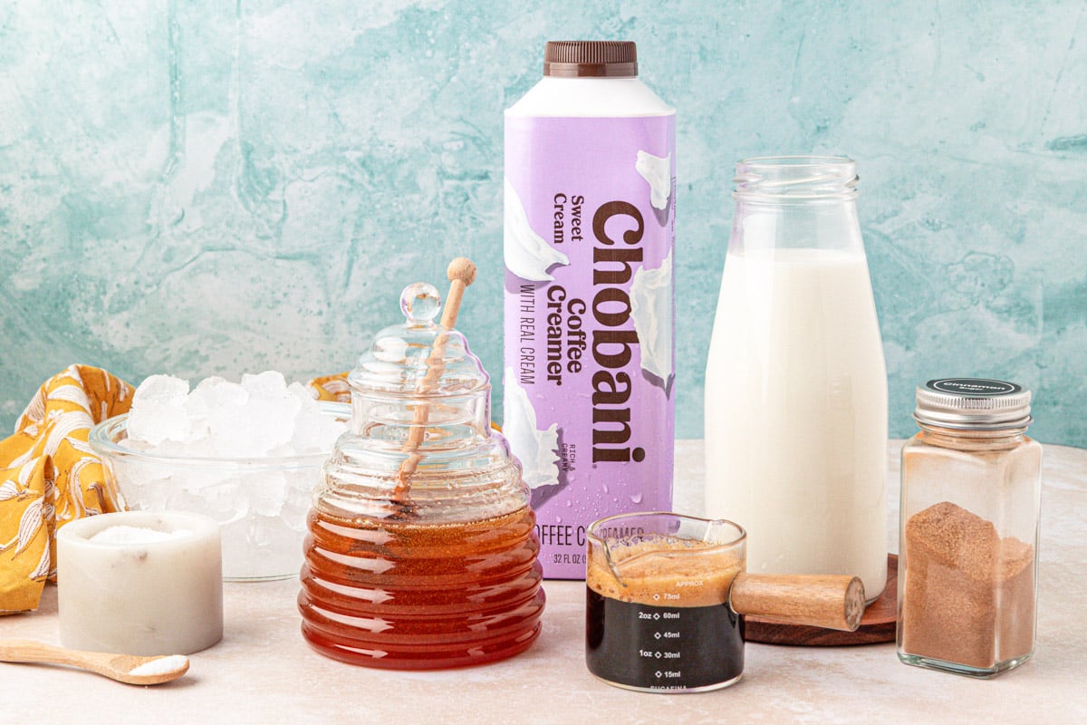Ingredients to make a salted honey iced latte on a table.