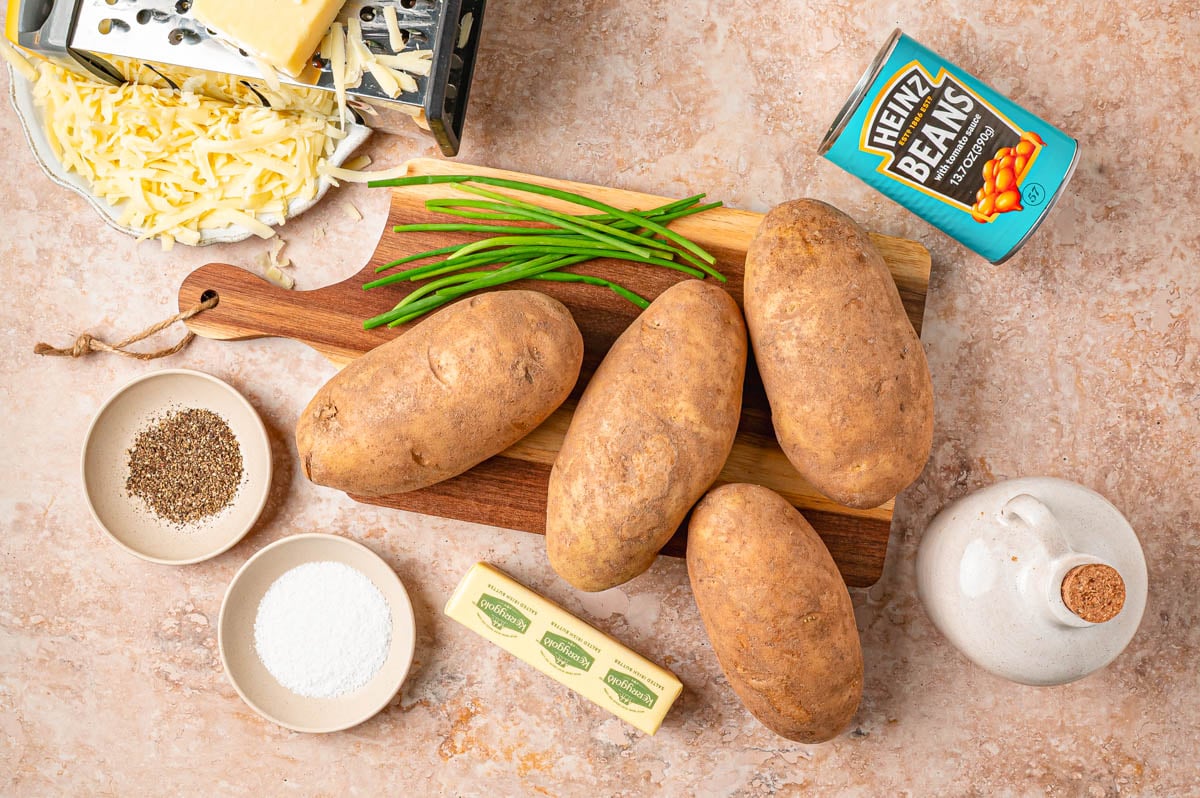 Ingredients to make beans and cheese loaded jacket potatoes on a table.