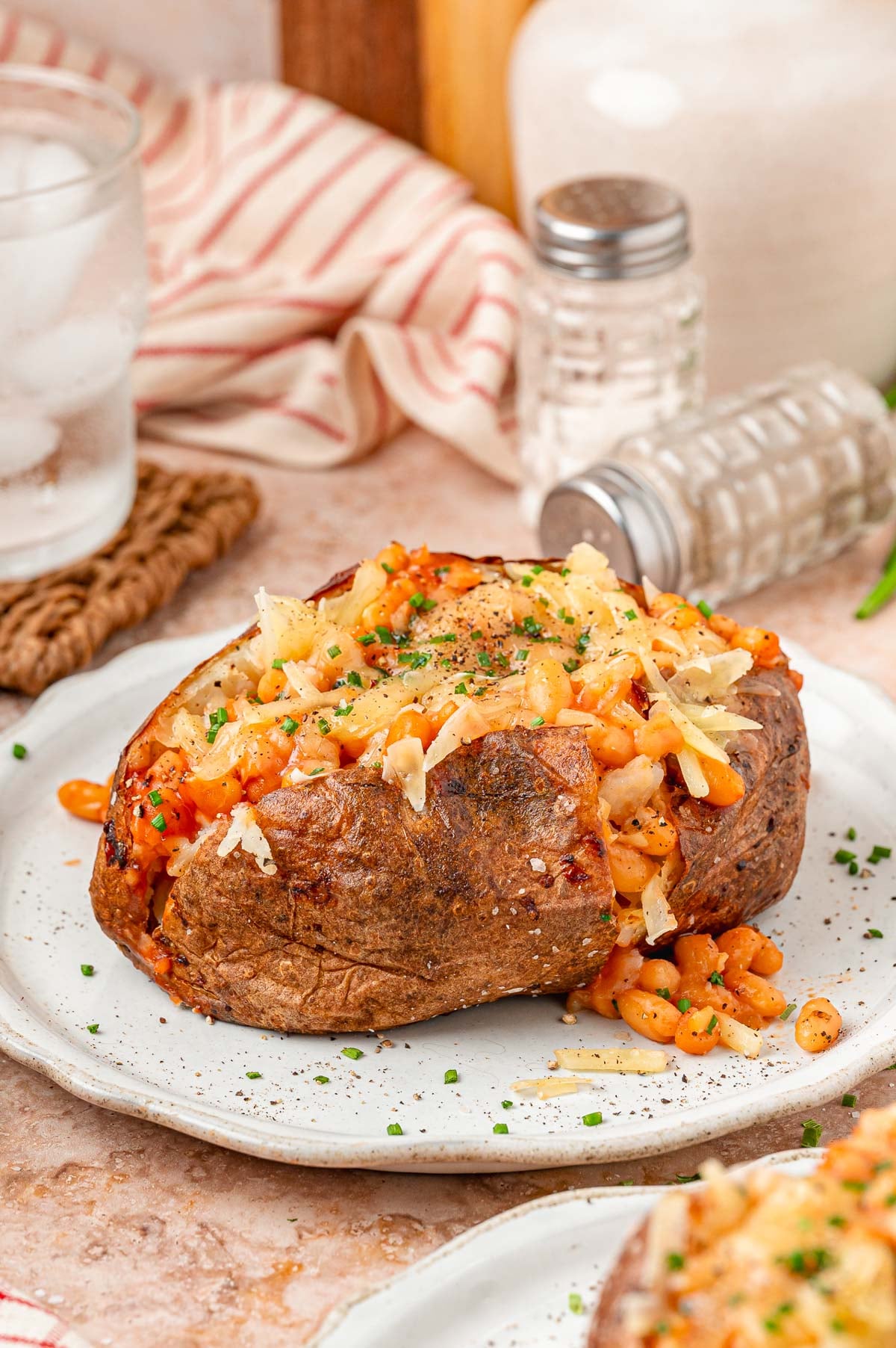 Loaded Jacket Potato with beans and cheese on a white plate.
