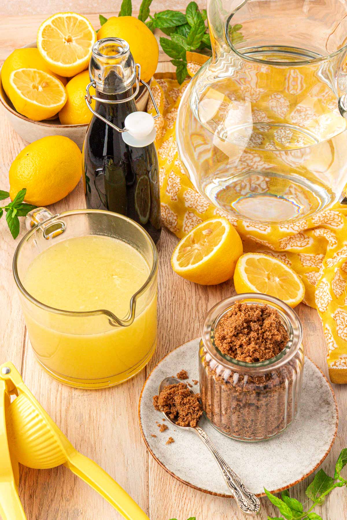 Ingredients to make brown sugar lemonade on a light wood table.