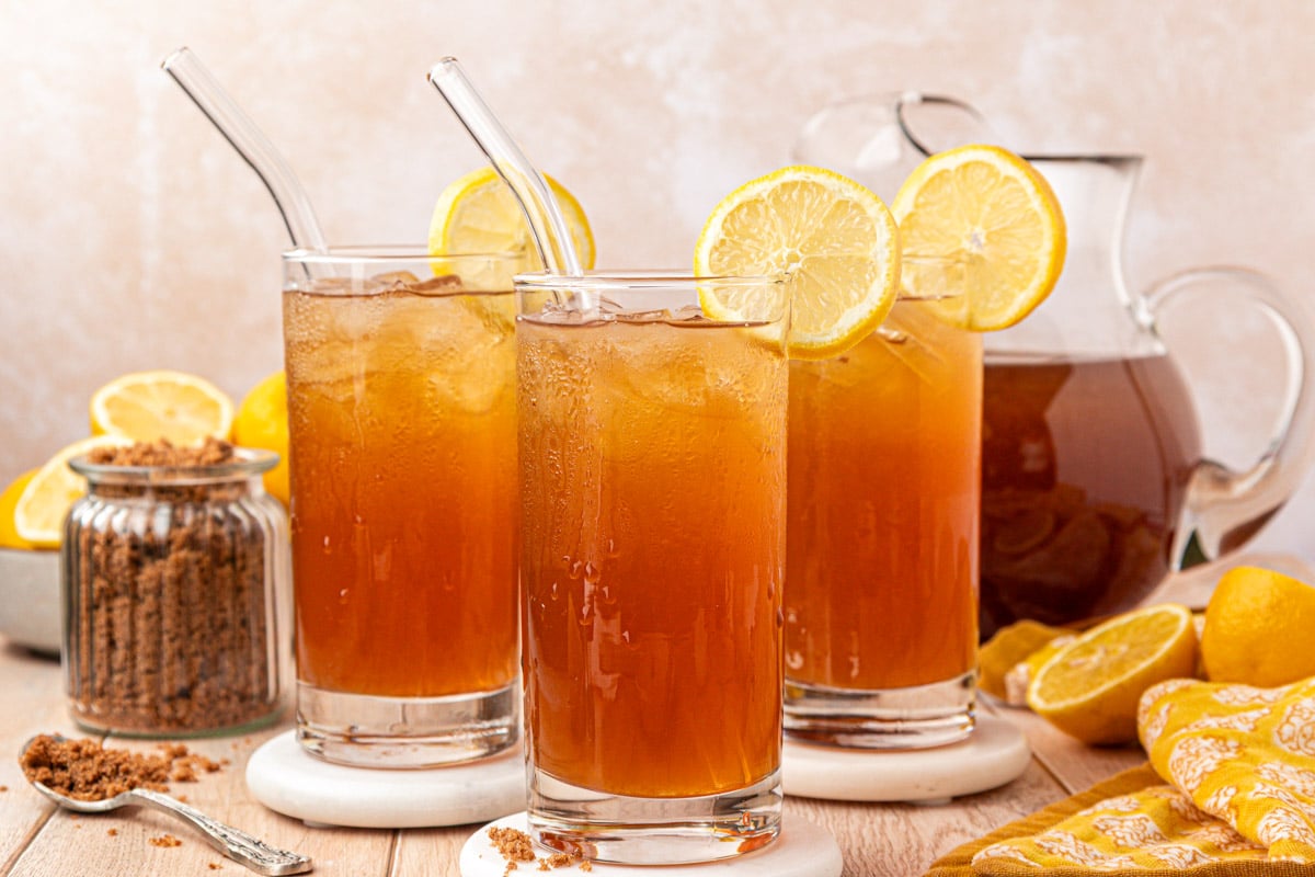 Three glasses of brown sugar lemonade on a table.
