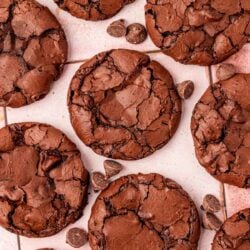 Flourless brownie cookies on a pink tile table.