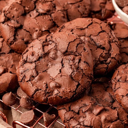 Flourless brownie cookies piled on a wire rack.
