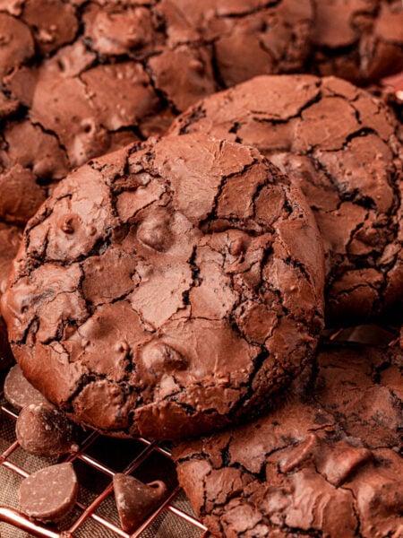 Flourless brownie cookies piled on a wire rack.