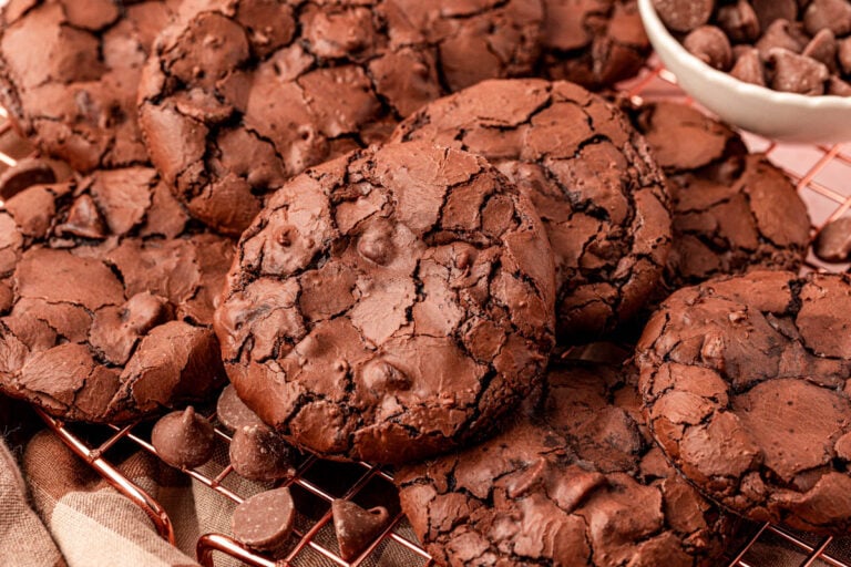 Flourless brownie cookies piled on a wire rack.