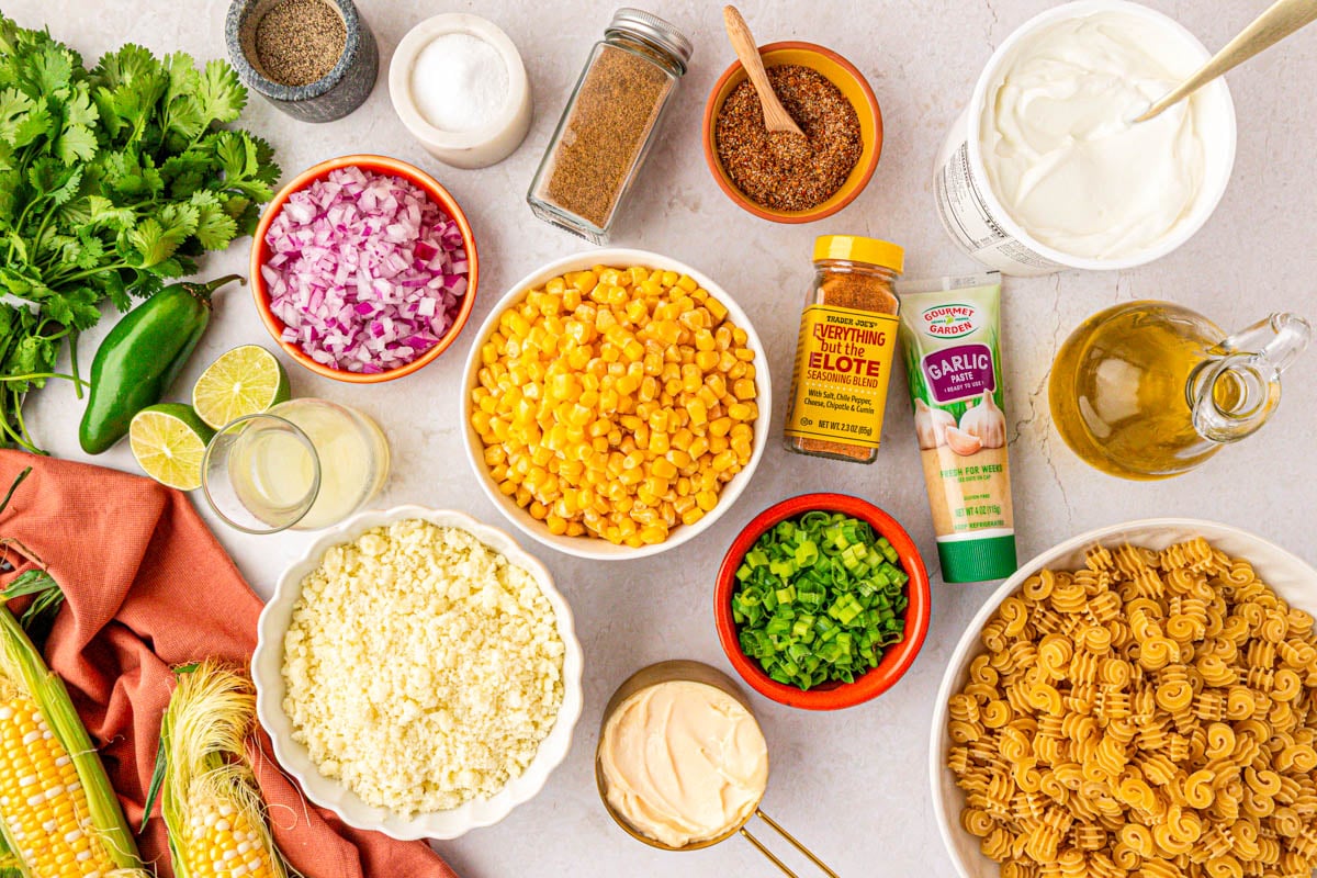 Overhead phot of ingredients prepped to make street corn pasta salad on a table.