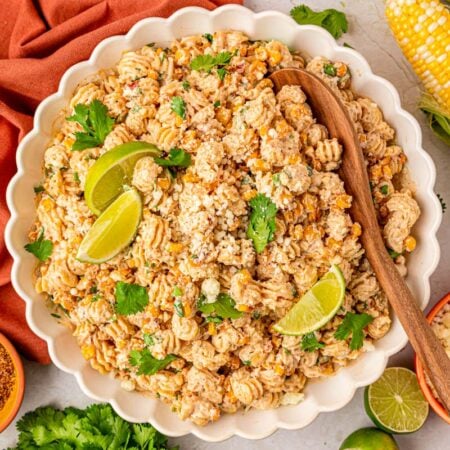 a white scalloped bowl of street corn pasta salad.