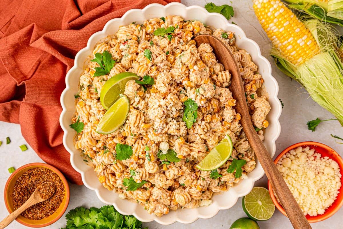 a white scalloped bowl of street corn pasta salad.