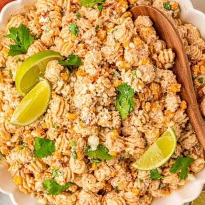 Close up of a bowl of pasta salad with elote flavors.