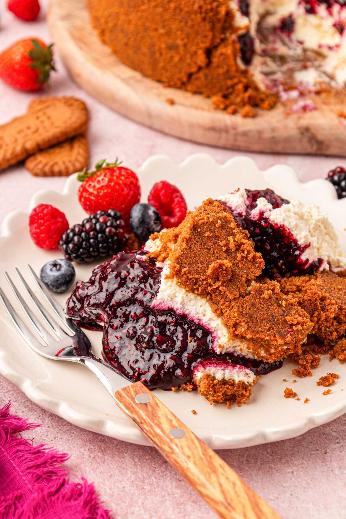 A plate of upside down cheesecake with mixed berry compote on a white plate.