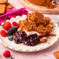 A plate of upside down cheesecake with mixed berry compote on a white plate.