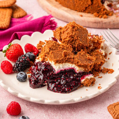 A plate of upside down cheesecake with mixed berry compote on a white plate.