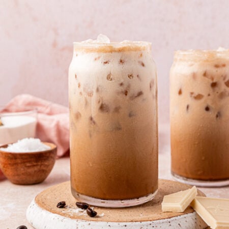 Two glasses filled with iced Washington americanos on a table.