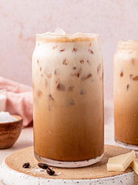 Two glasses filled with iced Washington americanos on a table.