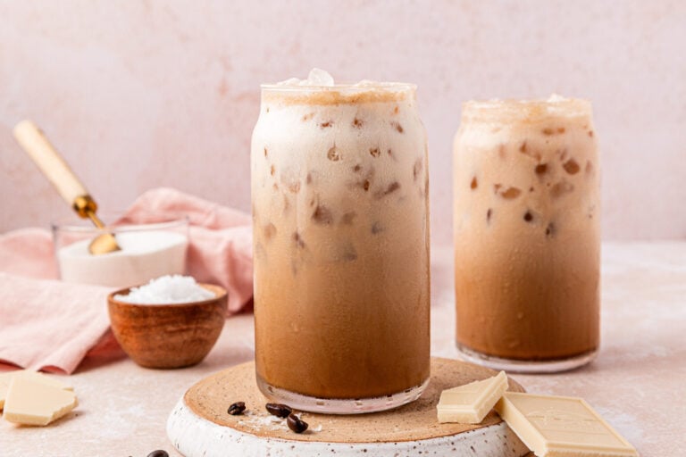 Two glasses filled with iced Washington americanos on a table.